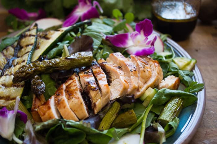 Spring Chicken Roasted Asparagus Salad- the perfect spring Whole30 recipe with a Beet Orange Basil Vinaigrette dressing that actually will make you CRAVE salad. Spring time vegetables are tossed with a Whole30 dressing and topped with grilled chicken.