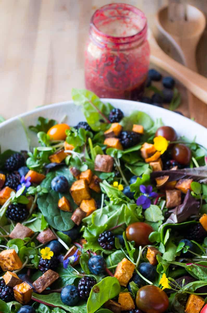 Veil of the Fairies Salad- A Whole30 vegetarian salad recipethat bursting with ripe Spring berries, dandelion greens, and topped with a delicious blueberry lemon basil beet dressing. 