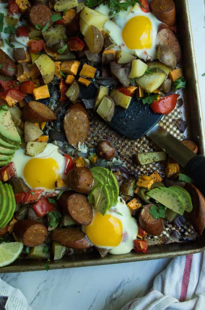 Whole30 Spicy Sheet pan Breakfast, a simple quick and colorful breakfast that prefect for meal prep, family gatherings, or an easy breakfast for dinner. A medley of potatoes and veggies are tossed with avocado oil, spices and roasted until crispy and caramelized in the oven. Then finished with chicken sausage and freshly cracked eggs. This is the breakfast dreams are made of.