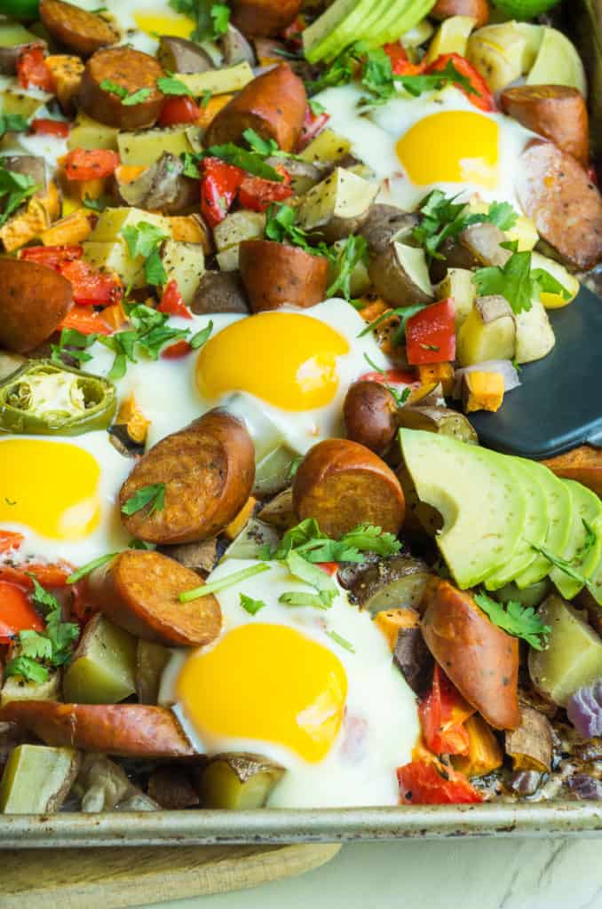 Whole30 Spicy Sheet pan Breakfast, a simple quick and colorful breakfast that prefect for meal prep, family gatherings, or an easy breakfast for dinner. A medley of potatoes and veggies are tossed with avocado oil, spices and roasted until crispy and caramelized in the oven. Then finished with chicken sausage and freshly cracked eggs. This is the breakfast dreams are made of.