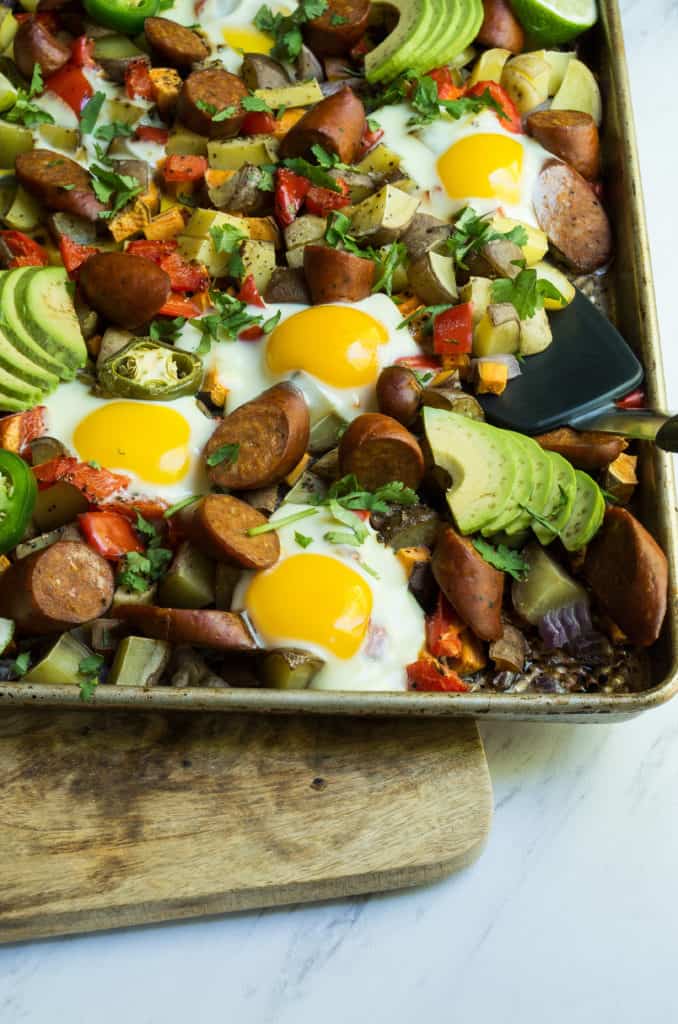 Whole30 Spicy Sheet pan Breakfast, a simple quick and colorful breakfast that prefect for meal prep, family gatherings, or an easy breakfast for dinner. A medley of potatoes and veggies are tossed with avocado oil, spices and roasted until crispy and caramelized in the oven. Then finished with chicken sausage and freshly cracked eggs. This is the breakfast dreams are made of.