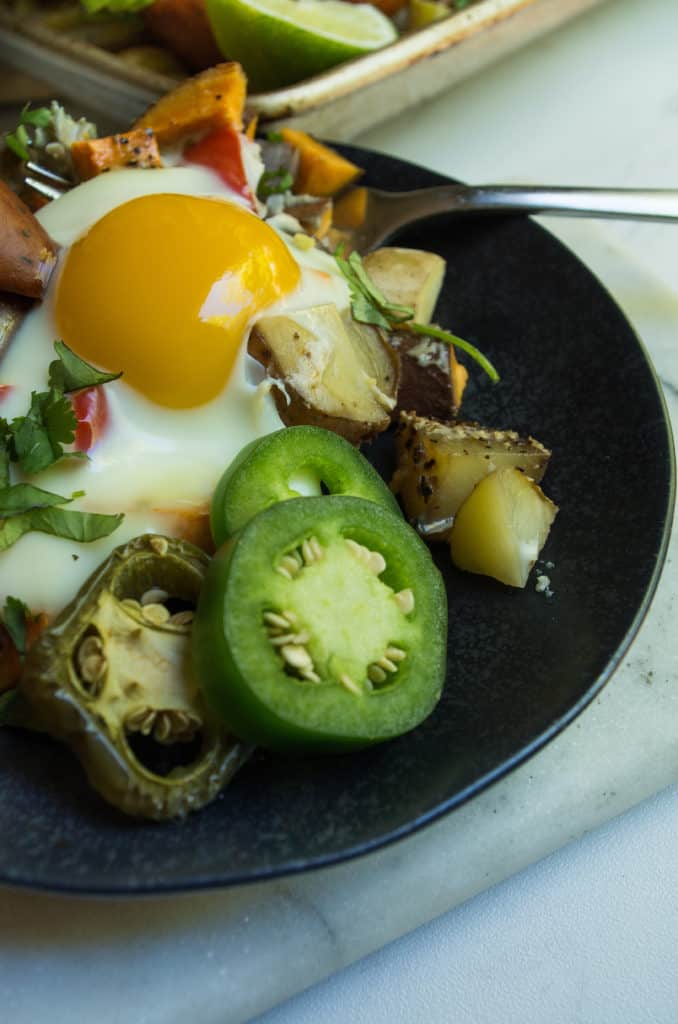 Whole30 Spicy Sheet pan Breakfast, a simple quick and colorful breakfast that prefect for meal prep, family gatherings, or an easy breakfast for dinner. A medley of potatoes and veggies are tossed with avocado oil, spices and roasted until crispy and caramelized in the oven. Then finished with chicken sausage and freshly cracked eggs. This is the breakfast dreams are made of.