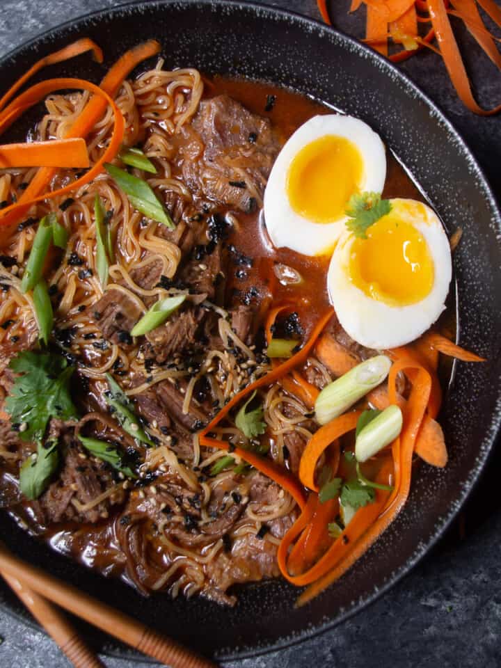 Large shallow bowl filled with ramen, broth, and short ribs