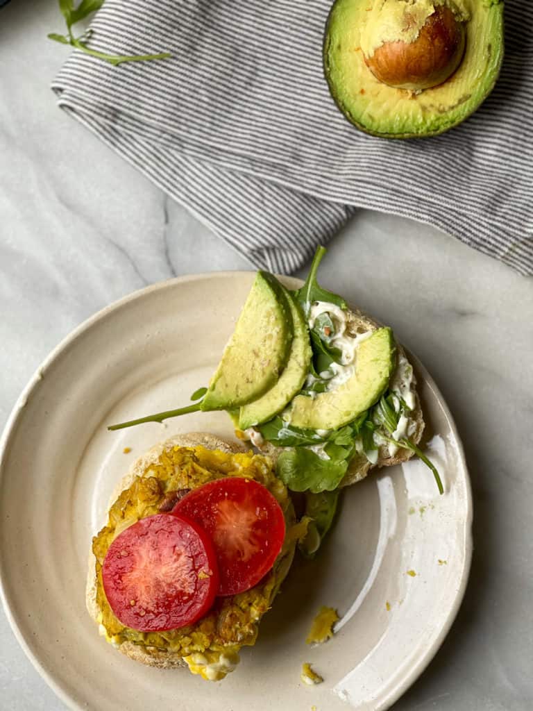 The Ultimate Vegetarian Breakfast Sandwich with a homemade meatless patty, soft scrambled eggs, avocado slices, tomato, and arugula. Good things happen when you make this breakfast sandwich.