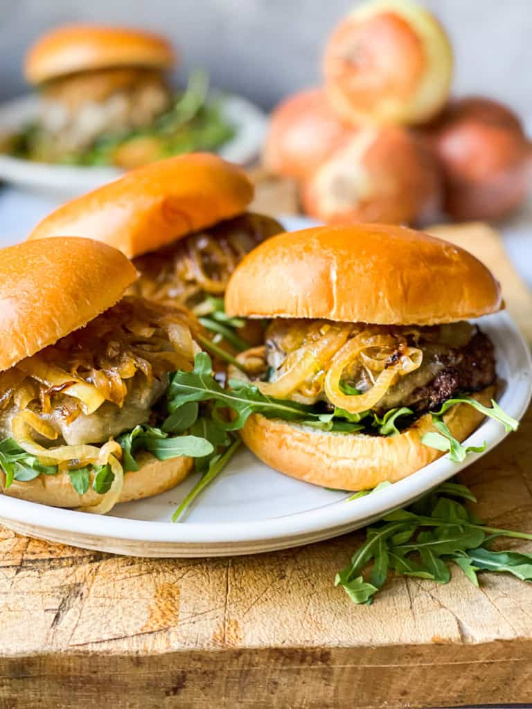 Caramelized Onion burgers with cheese with arugula on a plate