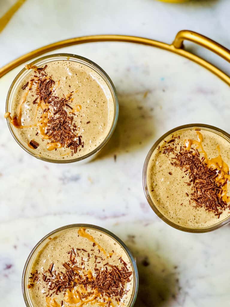 3 glasses filled with chocolate peanut butter smoothie