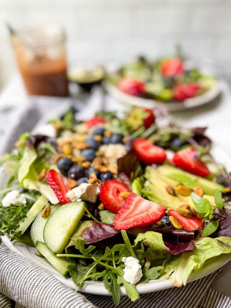 Mixed green salad with strawberries on a big plate