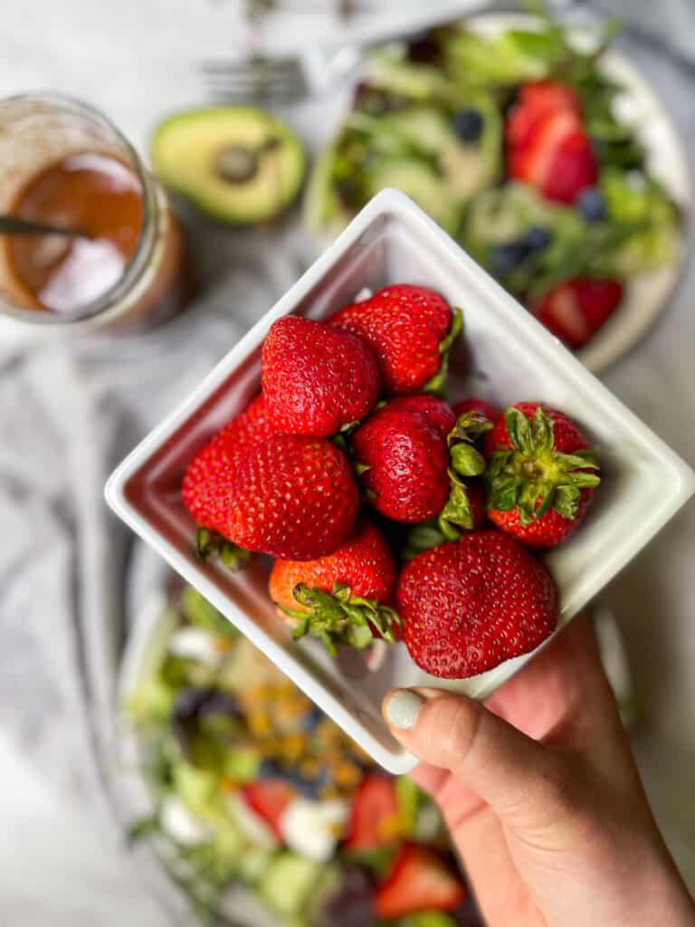 Mixed green salad with strawberries on a big plate
