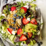 Mixed green salad with strawberries on a big plate