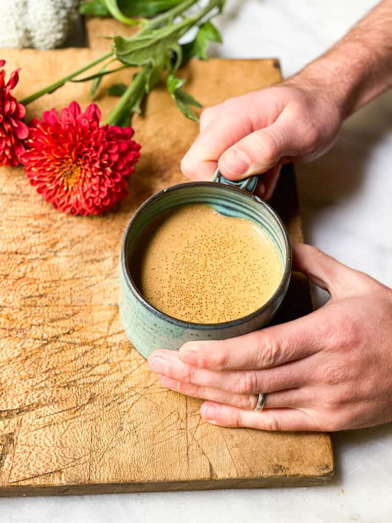 Whole30 Pumpkin Spice Latte being held in a blue mug