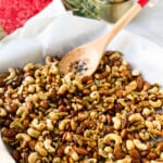 Roasted Rosemary Party Nuts on a Baking Sheet with wooden spoon for serving