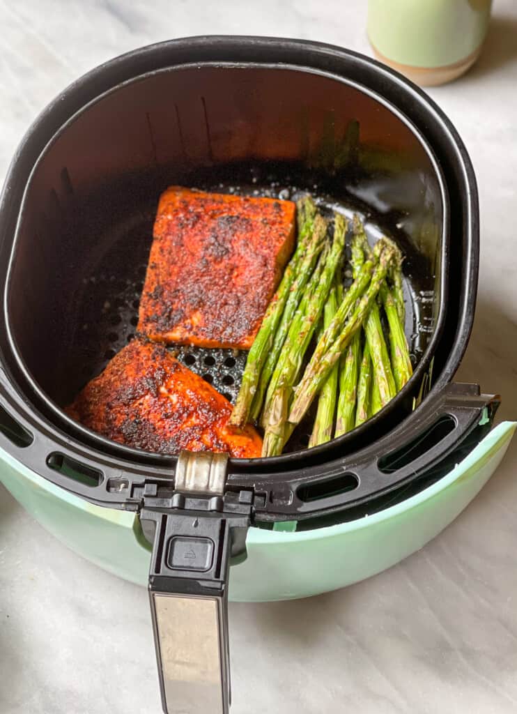 Chili Lime air fryer salmon in an air fryer basket with asparagus 