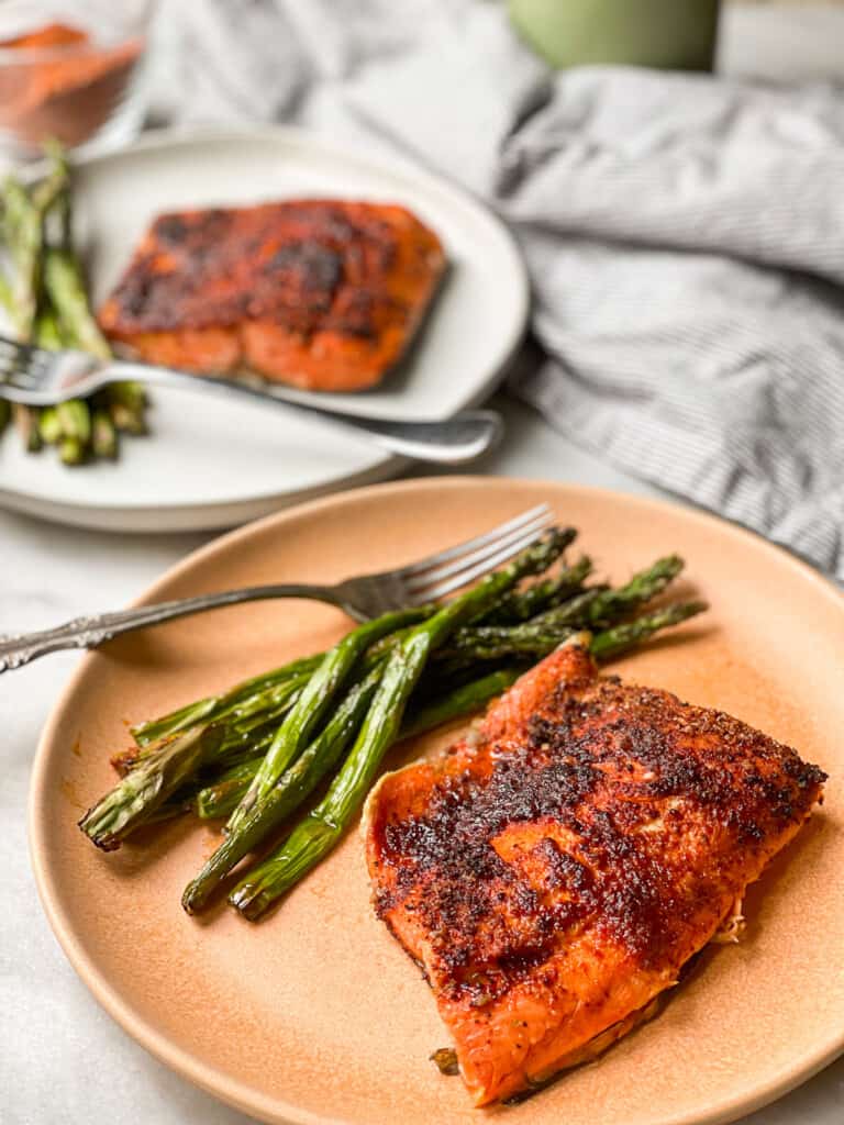 Chili Lime Air Fryer Salmon on a plate with a side of asparagus on a white marble table top.