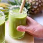 Tropical Green Smoothie! - An Actually Tasty Green Smoothie in a clear glass with coconut shreds on the rim. #cleaneating #greensmoothie #plantbased #breakfast #smoothie #mealplanning
